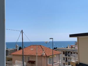 Ein Vogel fliegt über ein Gebäude mit dem Ozean im Hintergrund in der Unterkunft Casa Bonello 12 in Sanremo
