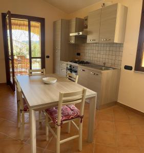 a kitchen with a wooden table and chairs in a room at Villa Patrizia in Castiadas +16 photos
