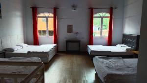 a room with three beds and two windows at Happy Garden in Kampong Tenompok