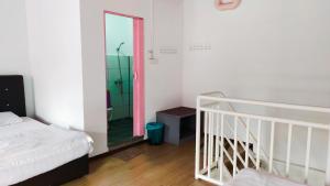 a bedroom with a bed and a shower and a mirror at Happy Garden in Kampong Tenompok