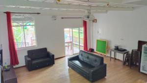 a living room with two chairs and a television at Happy Garden in Kampong Tenompok