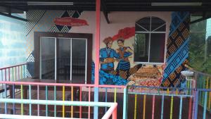a building with a mural on the side of it at Happy Garden in Kampong Tenompok