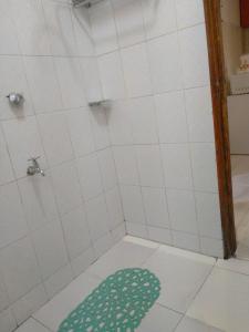 y baño con ducha y alfombra verde en el suelo. en Rovers Apartment en Nanyuki