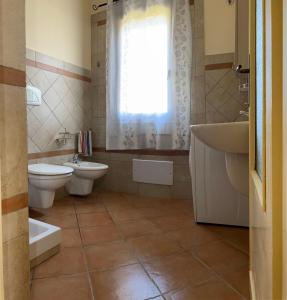 a bathroom with a toilet and a sink and a tub at Villa Patrizia in Castiadas