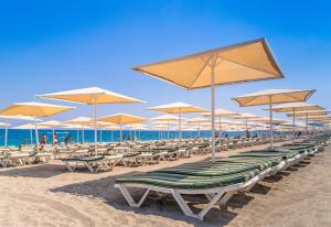 a row of chairs and umbrellas on a beach at L'Oceanica Beach Resort in Kemer