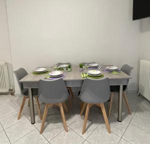 una mesa de comedor con sillas y platos. en Litsa's Apartment, en Igoumenitsa