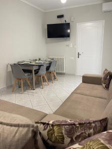 - un salon avec un canapé et une table avec des chaises dans l'établissement Litsa's Apartment, à Igoumenítsa