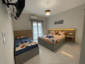 a bedroom with two beds and a tv in it at Litsa's Apartment in Igoumenitsa
