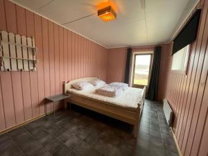 a small bedroom with a bed with a window at Summer house on Tjøme with beach and pier in Tjøme