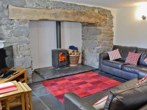 - un salon avec une cheminée en pierre et des canapés dans l'établissement Hen Dy, à Eglwys-Fâch