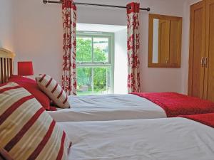 1 Schlafzimmer mit 2 Betten und einem Fenster in der Unterkunft Hen Dy in Eglwys-Fâch