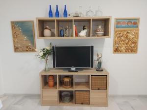 TV en un soporte de madera en la sala de estar en Apartamento Maria, en Chiclana de la Frontera