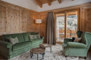 un soggiorno con un divano verde e 2 sedie di Hotel Baita Dei Pini a Bormio