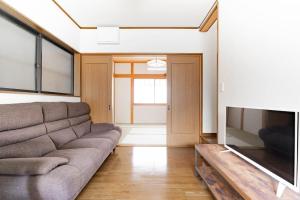 a living room with a couch and a flat screen tv at 悠の宿 in Osaka