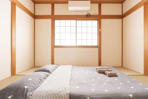 a large bed in a room with a window at 悠の宿 in Osaka