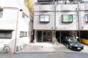 a car parked in a parking lot in front of a building at 悠の宿 in Osaka