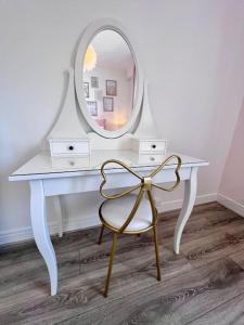 une coiffeuse blanche avec un miroir et une chaise dans l'établissement Casa Bert - Moderne & Design T2 - Centre Ville - Parking Gratuit, à Brive-la-Gaillarde