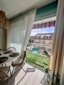 een kamer met een groot raam met een tafel en stoelen bij Casa Bert - Moderne & Design T2 - Centre Ville - Parking Gratuit in Brive-la-Gaillarde