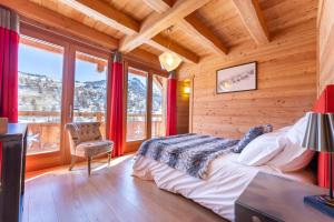 1 dormitorio con 1 cama en una habitación con ventanas en Chalet Mountainside avec sauna et jacuzzi à 200m des pistes, en Vars