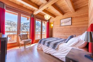sypialnia z łóżkiem w pokoju z oknami w obiekcie Chalet Mountainside avec sauna et jacuzzi à 200m des pistes w mieście Vars