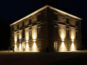 a large building with lights on it at night at Château de Crespy & Suites 