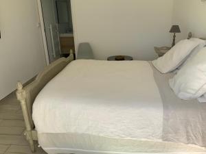 a large white bed in a room with at Le Mas de la Dame in Saint-Tropez