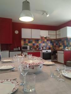 a kitchen with a table with plates and wine glasses at Bienvenue au gîte de Claret in Casseneuil
