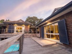 a deck with a pool and a house at 10 St Andrews Avenue in Natureʼs Valley