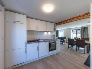 a kitchen with white cabinets and a dining room at HafenApartment im Herzen von Malchow in Malchow