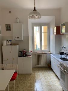 a kitchen with white cabinets and a table and a window at Clara Luna appartamento turistico in Osimo