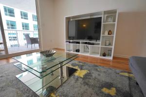 a living room with a glass table and a flat screen tv at City & Sea View+FREE Parking Modern Condo in Miami