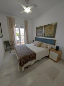 1 dormitorio con 1 cama grande y ventilador de techo en Apartamento Maria, en Chiclana de la Frontera