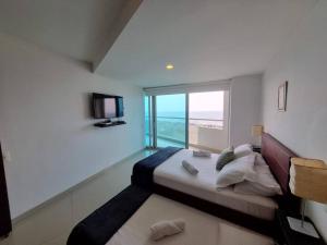 a bedroom with a large bed with a view of the ocean at 2 Dormitorios Playa Morros y Vista Mar in Cartagena de Indias