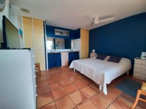 - une chambre avec un lit et un mur bleu dans l'établissement Superbe T4, vue mer, Narbonne Plage, à Narbonne-Plage