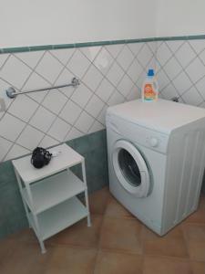 eine weiße Waschmaschine im Bad mit einem Tisch in der Unterkunft La Terrazza Fiorita in Nebida