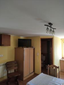 a kitchen with a refrigerator and a room with a table at Pokoje Noclegowe - Agroturystyka in Brzostek