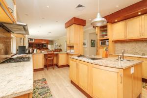 a large kitchen with wooden cabinets and a large island at 10 St Andrews Avenue in Natureʼs Valley