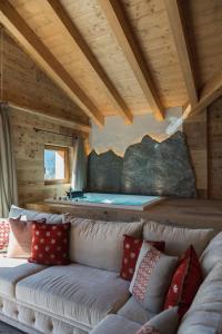 - un salon avec un canapé et un bain à remous dans l'établissement Hotel Baita Dei Pini, à Bormio