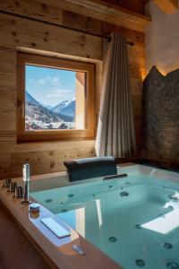 a bath tub in a room with a window at Hotel Baita Dei Pini in Bormio