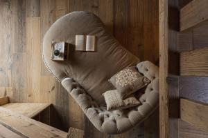 una silla con dos almohadas en una habitación en Hotel Baita Dei Pini en Bormio