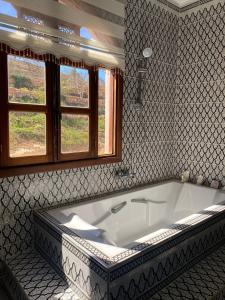 a bath tub in a bathroom with a window at Maison d'Hôte - Le Beau Panorama in Berkawe
