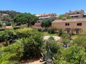 a garden with plants and trees and buildings at Appartement climatisé entre plage et port de Saint Mandrier in Saint-Mandrier-sur-Mer