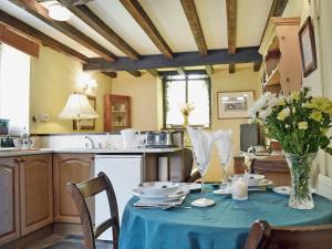 a kitchen with a table with a blue table cloth at Gamekeepers Cottage - Hw7729 in Myddfai