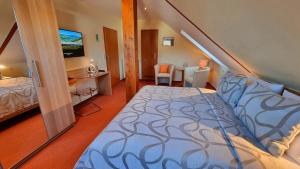 a bedroom with a bed and a desk and a television at Gasthaus Pension Moselgruss in Dieblich