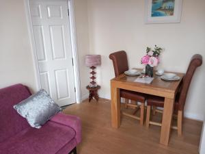 sala de estar con mesa y sofá púrpura en Victoria Quays Apartments, Fleetwood, en Fleetwood