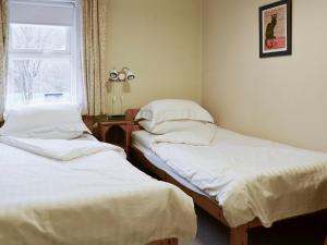 two twin beds in a room with a window at Brasscam in Rosthwaite