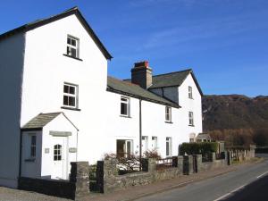 a white house on the side of a street at Brasscam in Rosthwaite