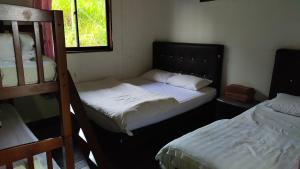a bedroom with two bunk beds and a window at Happy Garden in Kampong Tenompok