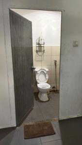 an open door to a bathroom with a toilet at Happy Garden in Kampong Tenompok