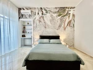 1 dormitorio con 1 cama y un mural en la pared en La Passeggiata di Girgenti, en Agrigento